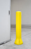 A bright yellow bollard post with a ribbed cylindrical design and a flared base, standing on a concrete floor next to a white door in a clean indoor setting.